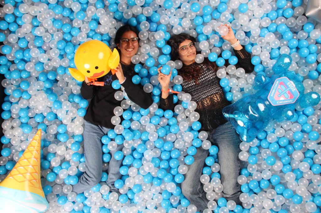 Two people posing for a Spring Photo Booth in a ball pit photo booth.