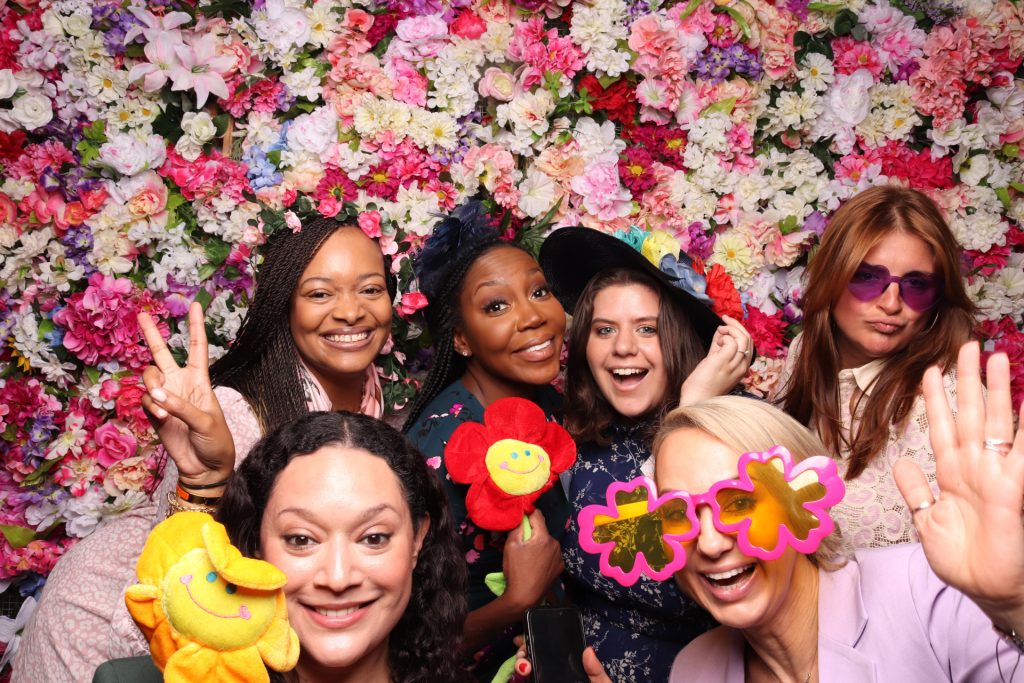 Group of women posing in front of the Floral Wall for a Spring Photo Booth