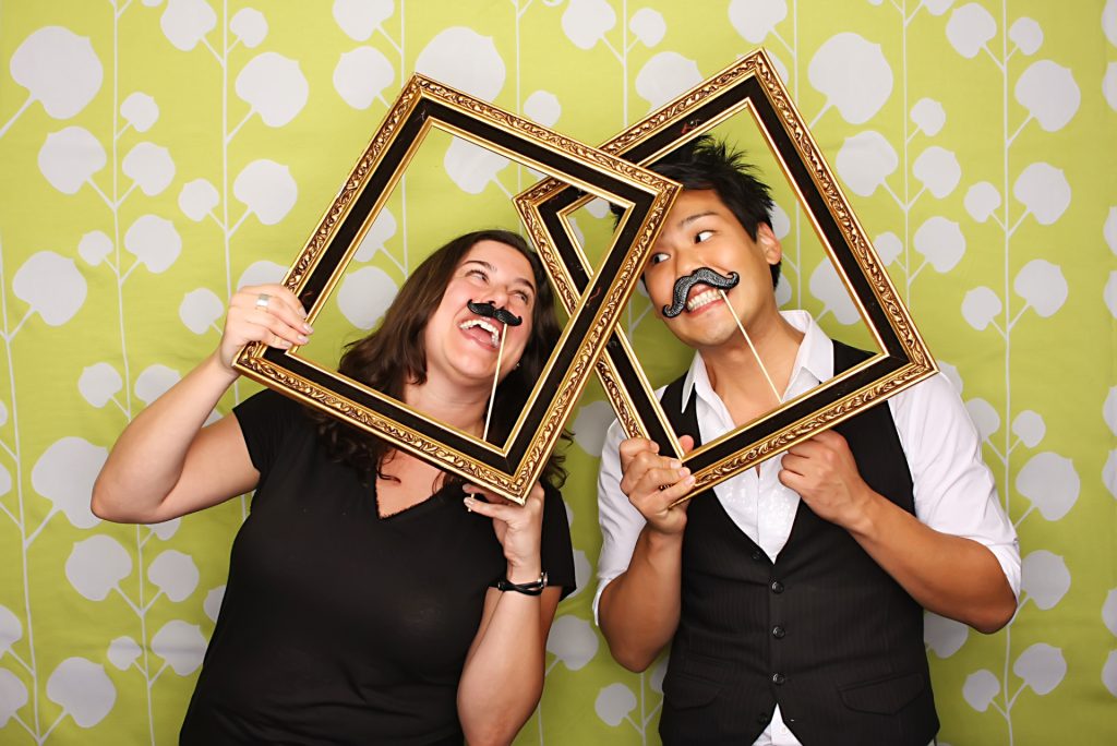 Two women posing for a photo in the Open-Air photo booth.