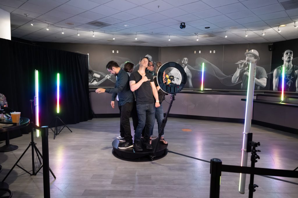 Guests enjoying a 360 video booth at a stylish Bay Area event, capturing fun, slow-motion video moments with custom backdrops and lighting effects.