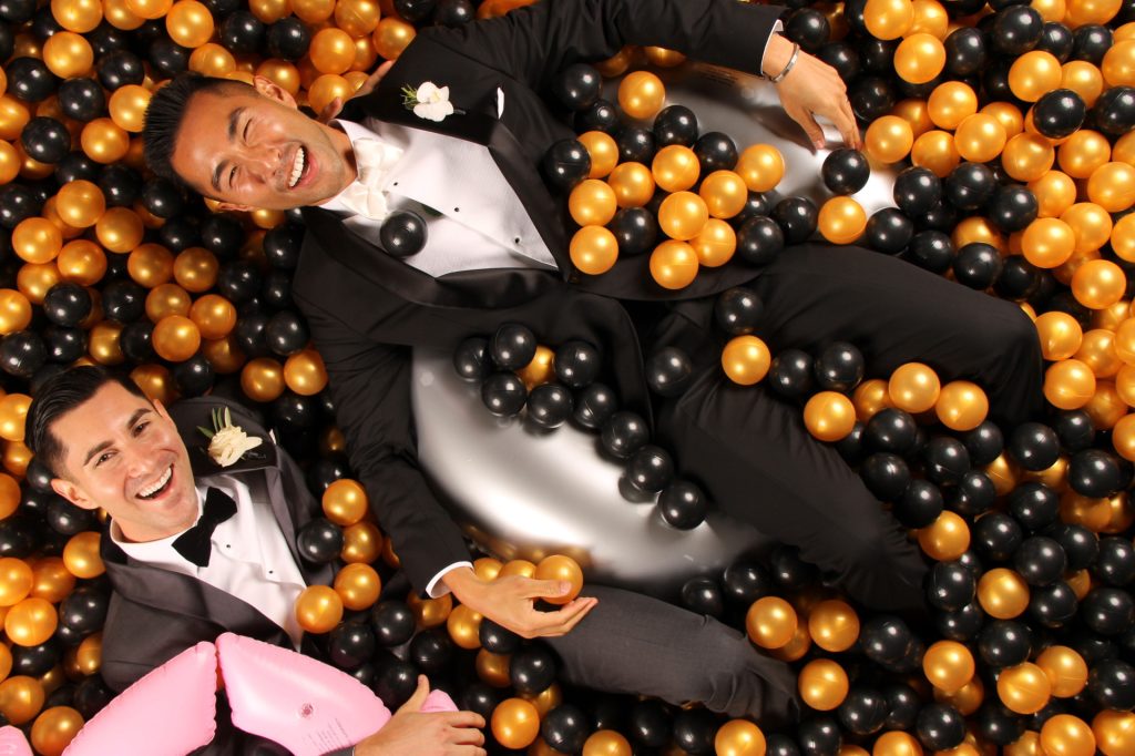 Two men sitting in a Ball Pit Wedding Photo Booth