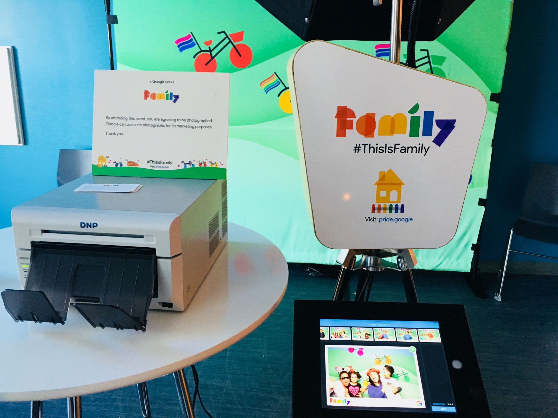 A SnapFiesta Open Air Photo Booth with a customized equipment wrap, a custom backdrop, and a customized information sign.