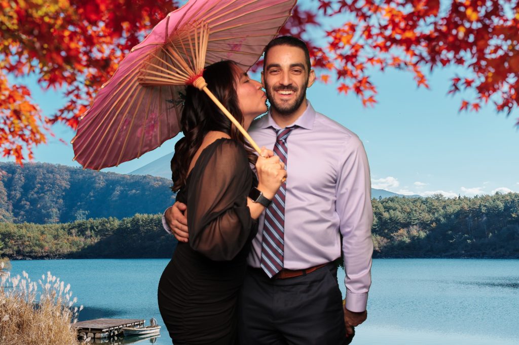 Couple posing for a photo in front of a Greenscreen Photo Booth.