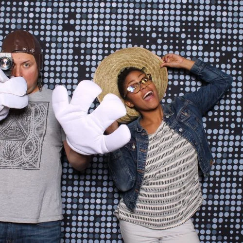 two people with silly hats and props in a photobooth