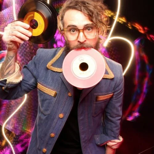 man posing in a light painting booth with small vinyls