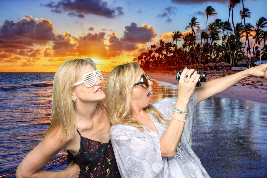 two women in front of a sunset background