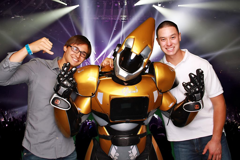 two men posing with a robot in a greenscreen photo booth