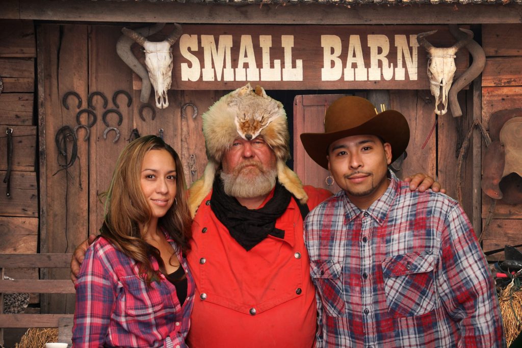 two men and a woman in front of a barn background