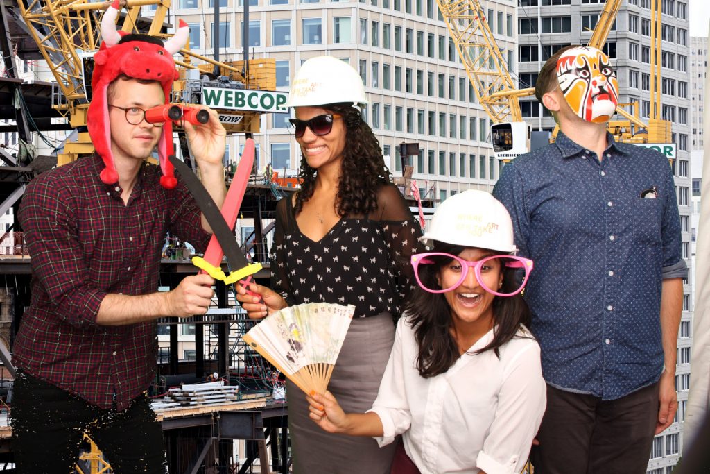 four people posing in front of a construction backdrop